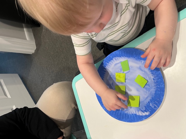Shaving cream and foam square sensory play on a paper plate