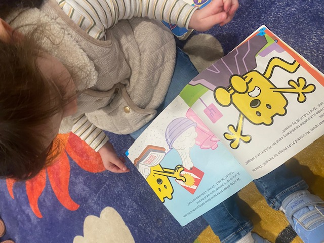 Reading a picture book on the classroom rug