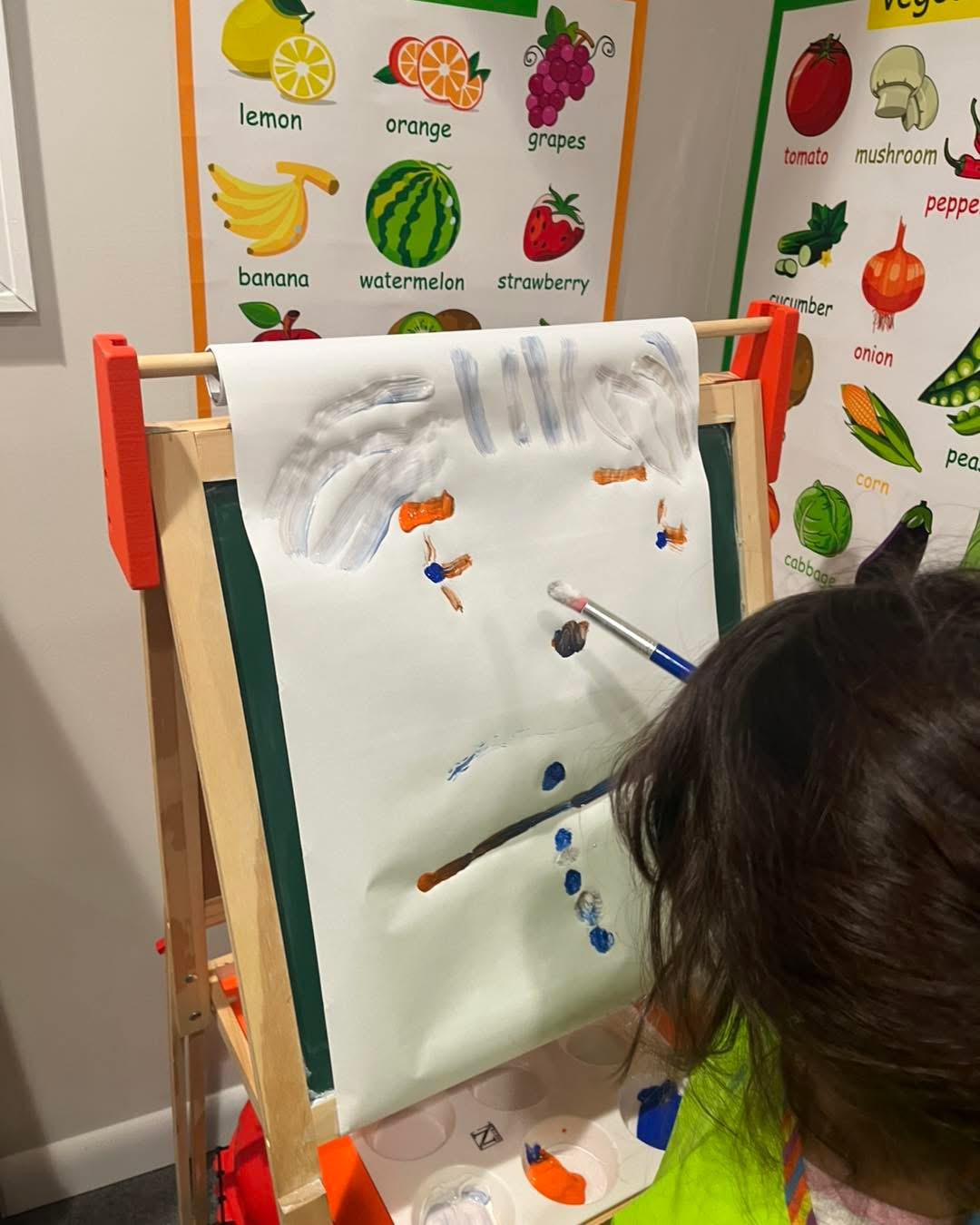 Toddler painting at the easel