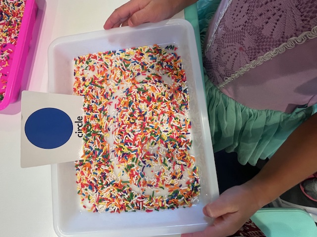 Sprinkle sensory bin with a circle shape card