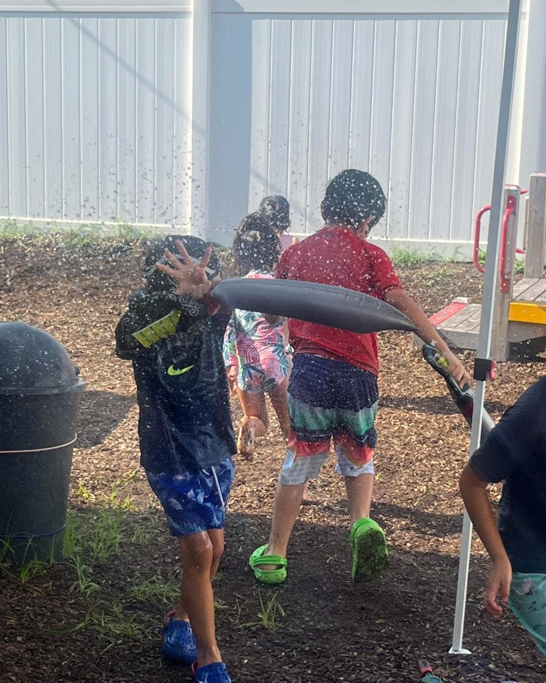 Children playing in the sprinkler outdoors