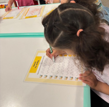 Practicing pre-writing lines and squiggles on a tracing sheet