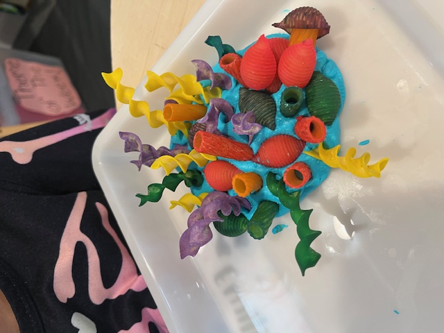 Finished pasta coral reef sculpture in blue sand