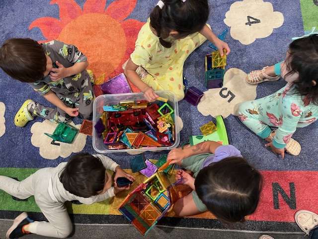 Building together with magnetic tiles on the rug